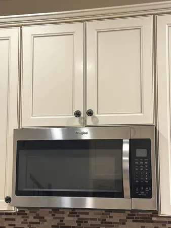 a kitchen with stainless steel appliances white cabinets and a stove top oven