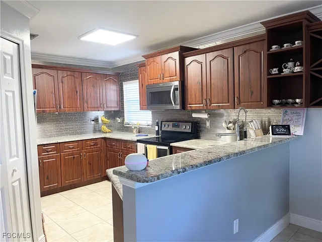 a kitchen with granite countertop a sink dishwasher stove and cabinets