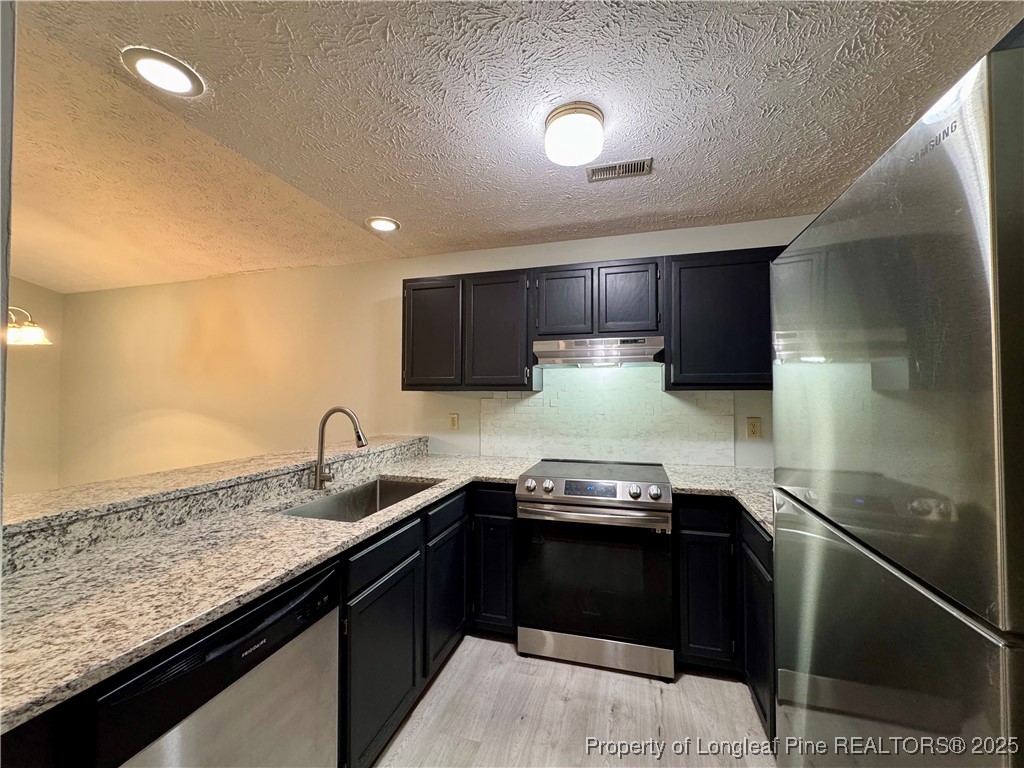 1899 Tryon Drive, Unit 8 Fayetteville, NC 28303 - Photo 10 of 21 a kitchen with granite countertop stainless steel appliances a sink stove top oven and cabinets