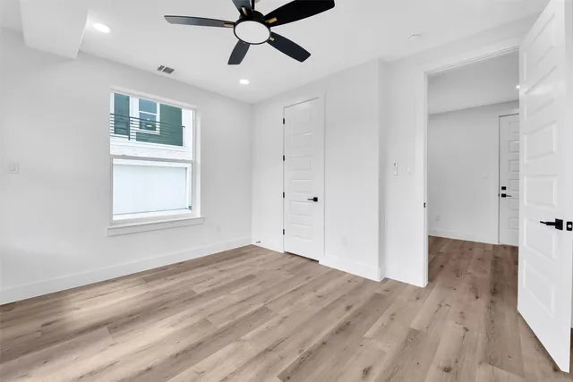 a view of a livingroom with a ceiling fan & entryway