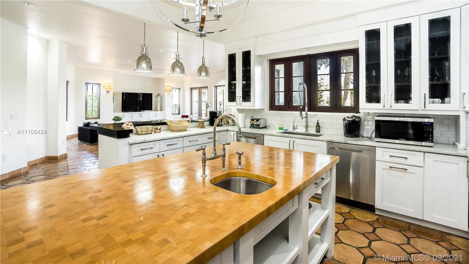 1201 Northeast 83rd Street Miami, FL 33138 - Photo 45 of 65 a kitchen with kitchen island a sink appliances and cabinets