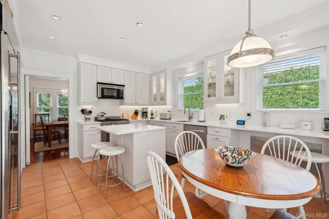 a kitchen with stainless steel appliances granite countertop a kitchen island a stove a table and chairs