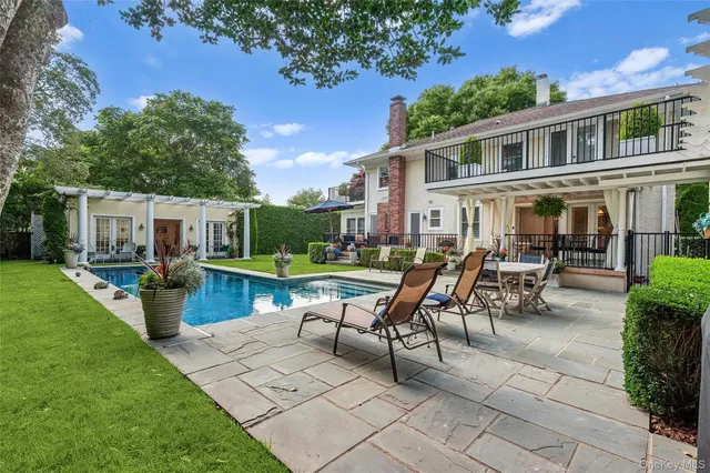 a swimming pool with outdoor seating and yard