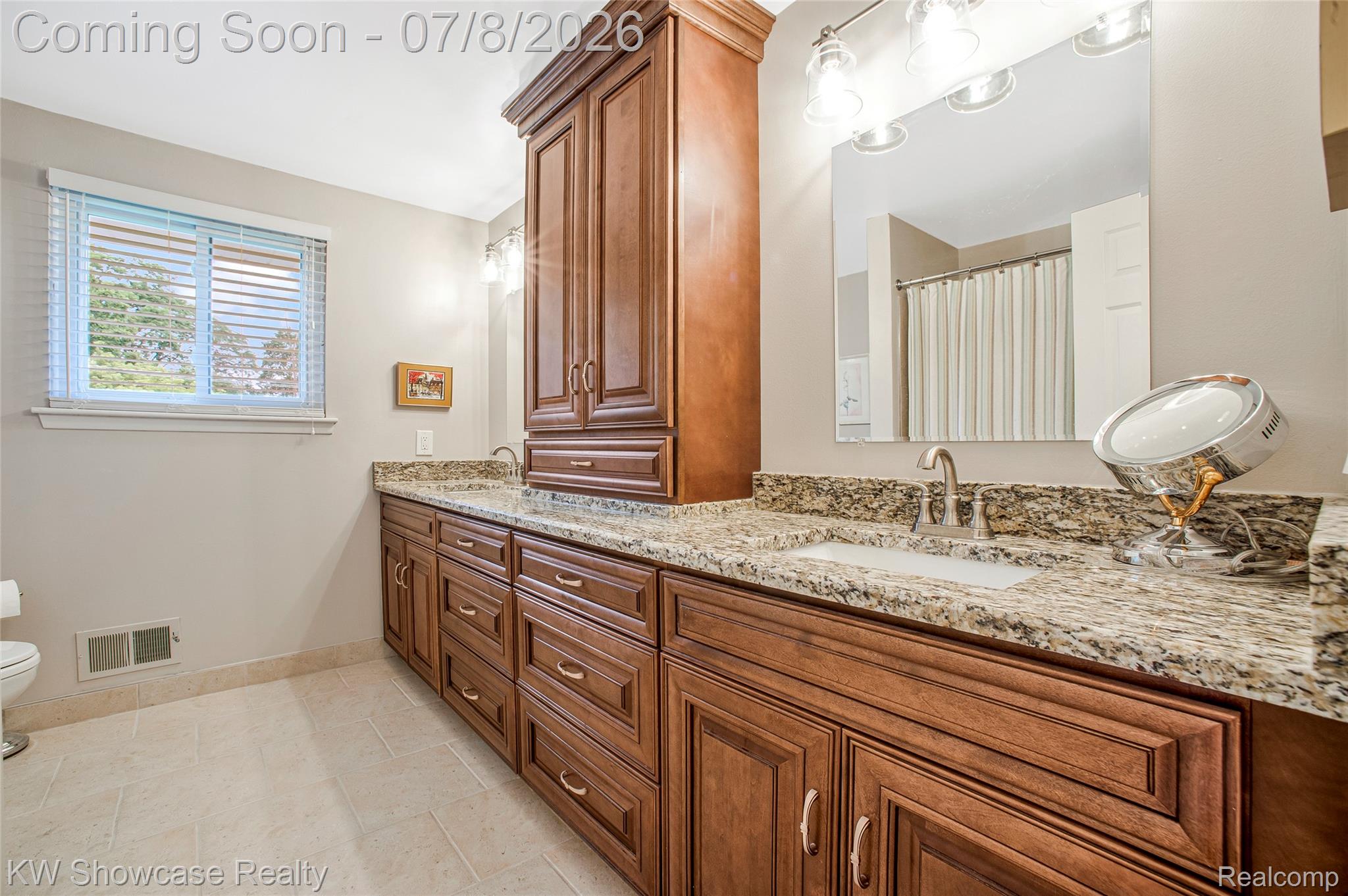 16720 Wayne Road Livonia, MI 48154 - Photo 23 of 29 Dual vanity with stone countertops, integrated sinks, and ample storage in wood cabinetry