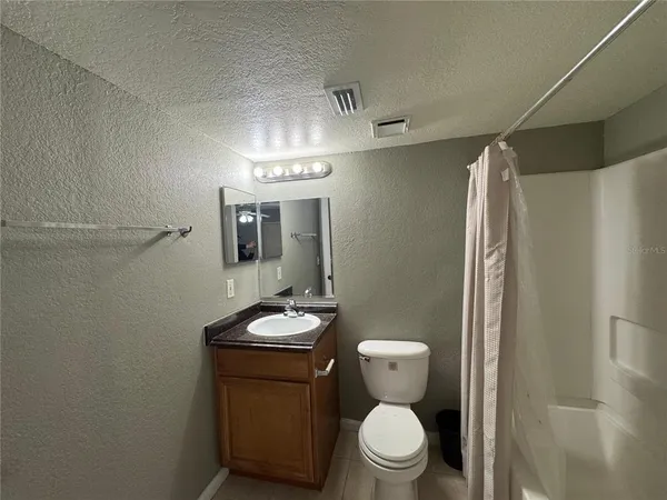 a bathroom with a toilet a sink and shower