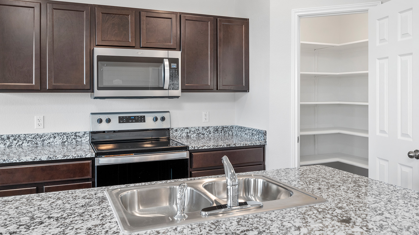 1418 Victory Rnch Trail Killeen, TX 76549 - Photo 4 of 22 A well-appointed kitchen showcasing a double basin sink and ample pantry storage.