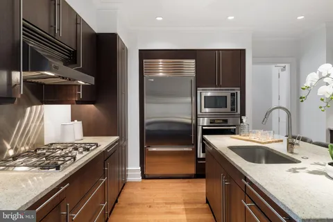 a kitchen with a sink cabinets and wooden floor