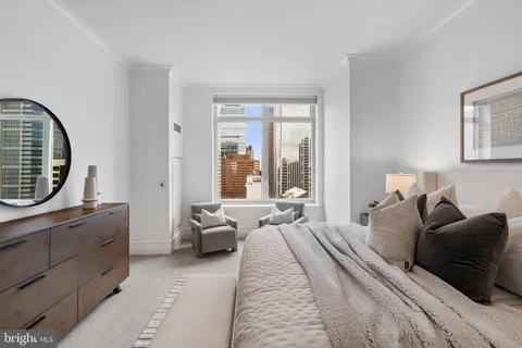 a bedroom with a bed couch and a large window