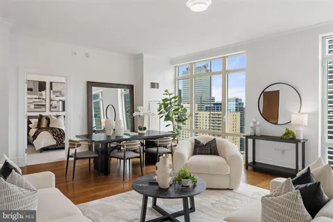 a living room with fireplace furniture and floor to ceiling windows