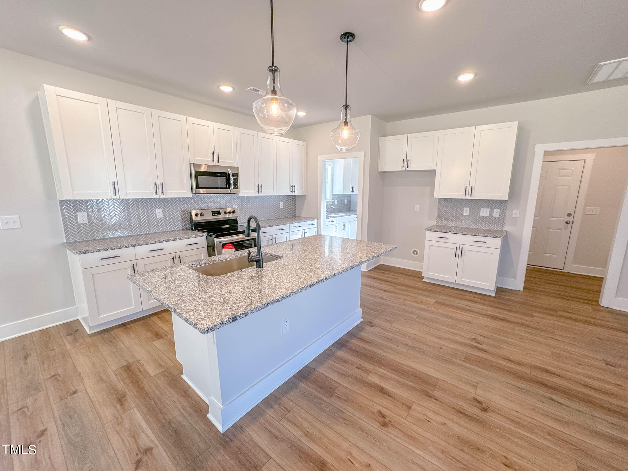 47 Beacon Hl Road, Unit SMITHFIELD Lillington, NC 27546 - Photo 11 of 69 a large kitchen with stainless steel appliances granite countertop a sink a stove and a wooden floors