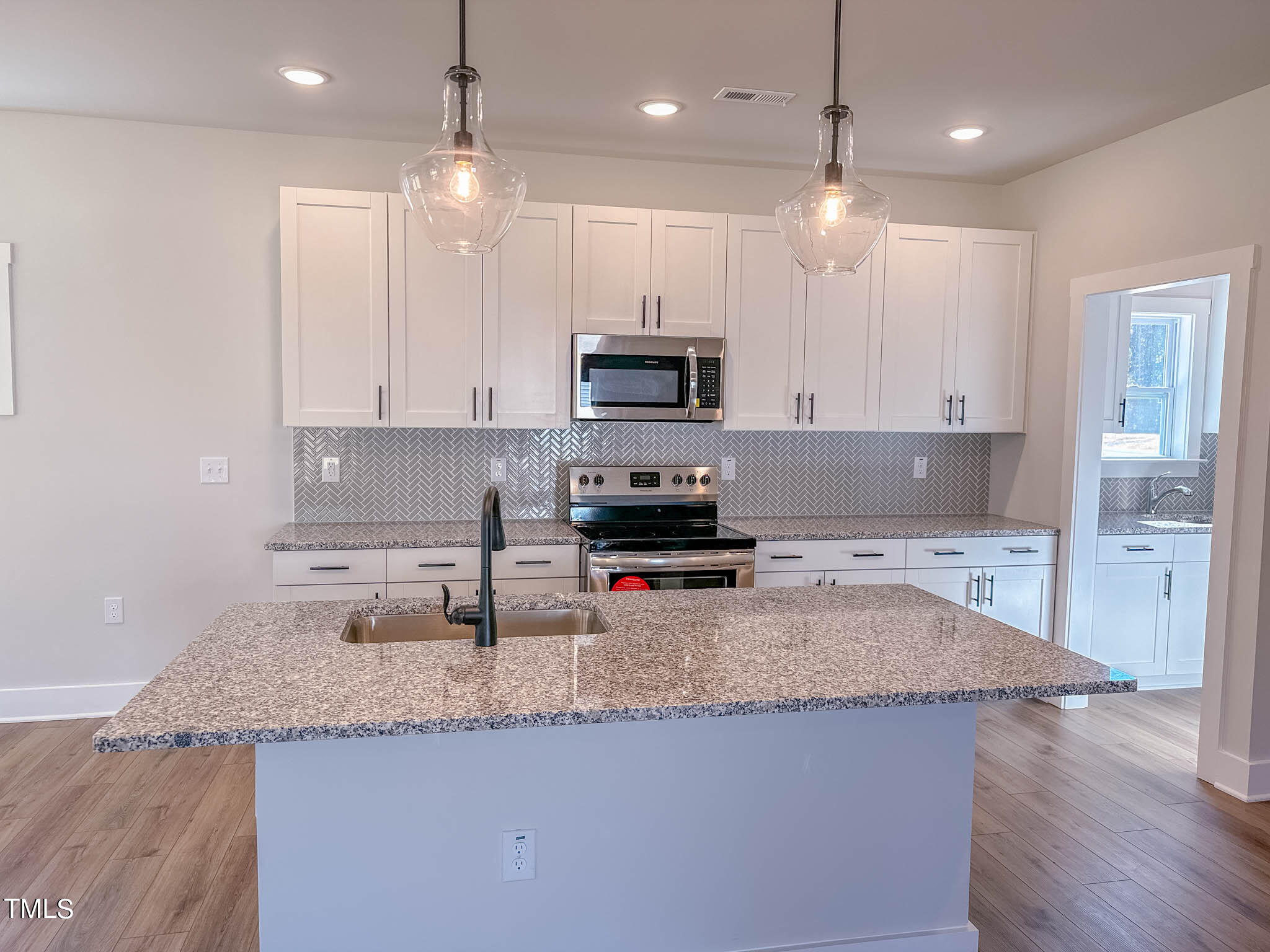 47 Beacon Hl Road, Unit SMITHFIELD Lillington, NC 27546 - Photo 12 of 69 a kitchen with granite countertop a stove a sink and a refrigerator