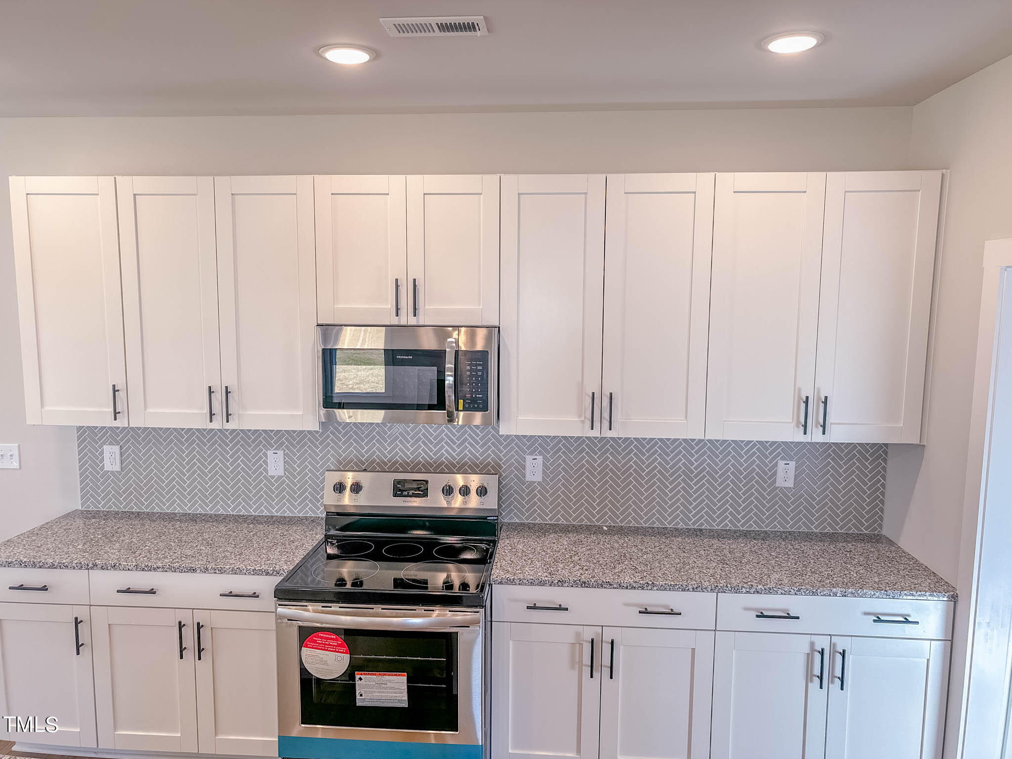 47 Beacon Hl Road, Unit SMITHFIELD Lillington, NC 27546 - Photo 14 of 69 a kitchen with granite countertop white cabinets and white appliances