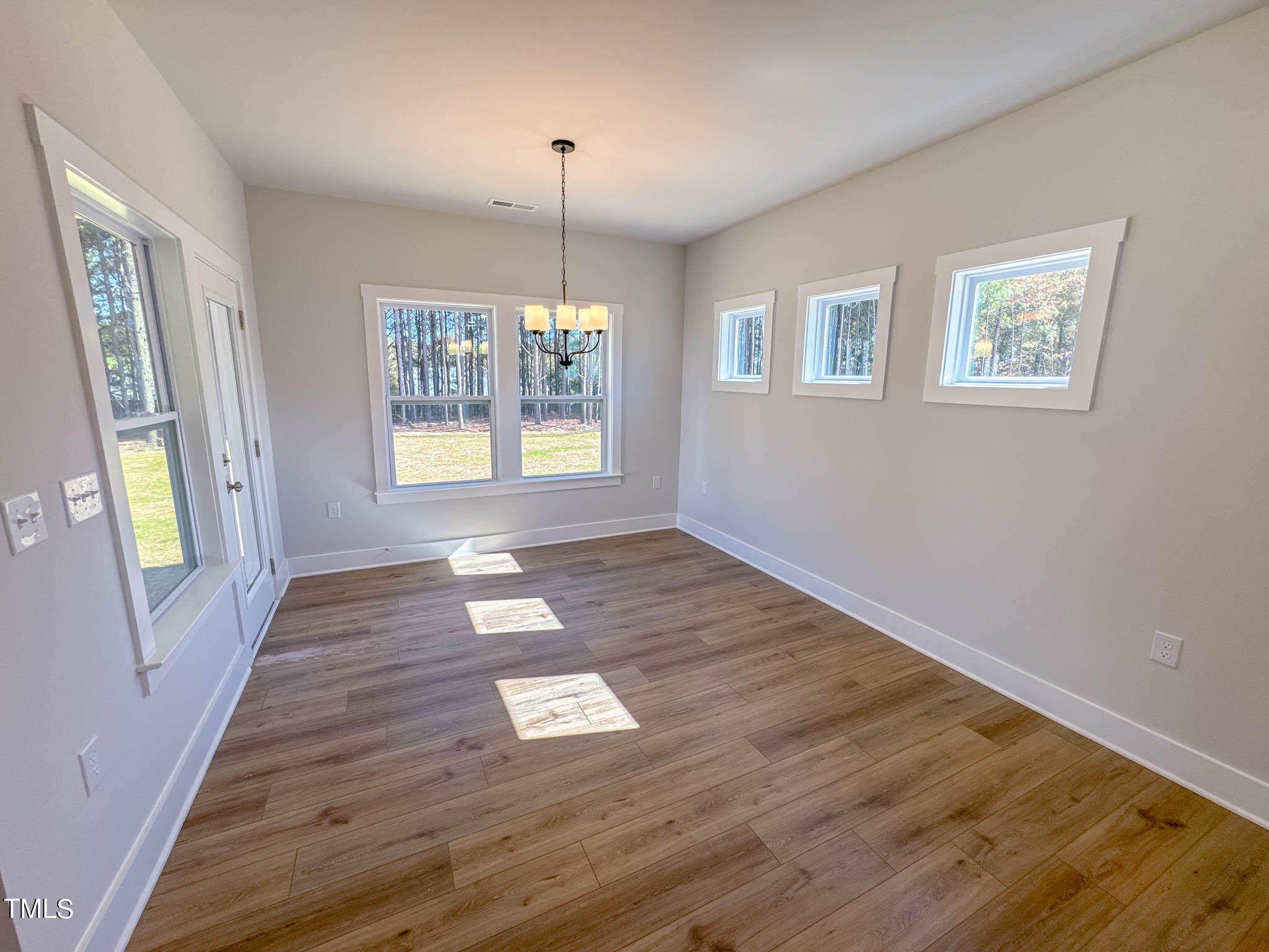 47 Beacon Hl Road, Unit SMITHFIELD Lillington, NC 27546 - Photo 21 of 69 a view of an empty room with wooden floor and a window
