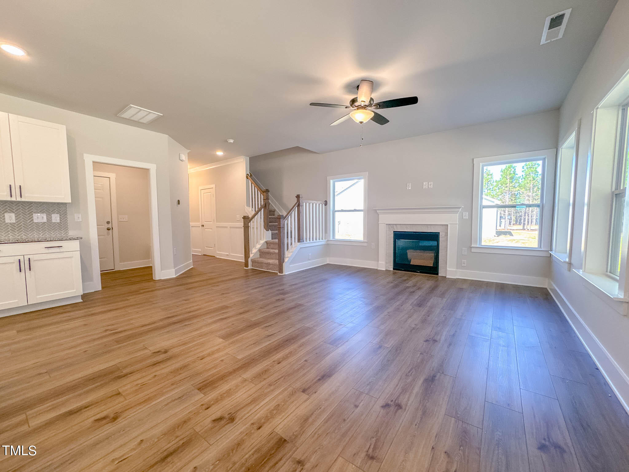 47 Beacon Hl Road, Unit SMITHFIELD Lillington, NC 27546 - Photo 23 of 69 an empty room with wooden floor fireplace cabinet and windows