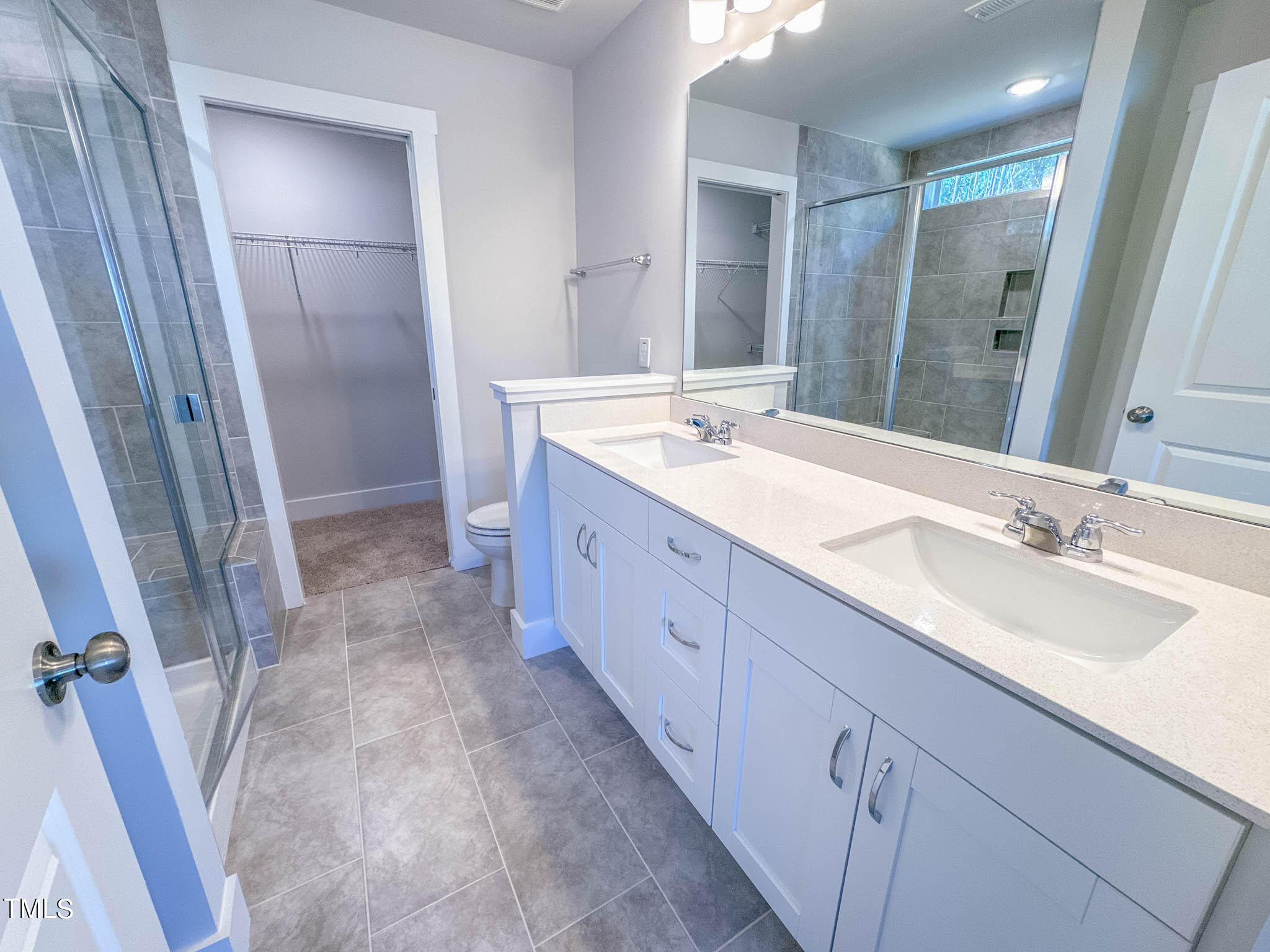 47 Beacon Hl Road, Unit SMITHFIELD Lillington, NC 27546 - Photo 57 of 69 a bathroom with a double vanity sink and mirror