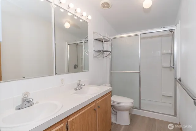 a bathroom with a granite countertop sink toilet a shower and a mirror