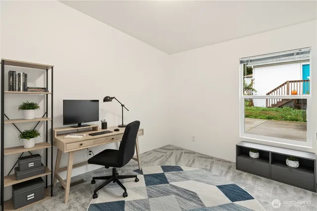 a view of a workspace with furniture and a window