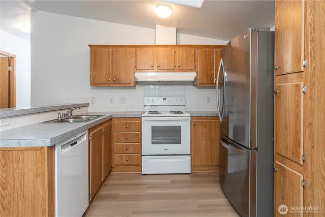 a kitchen with a refrigerator sink and cabinets