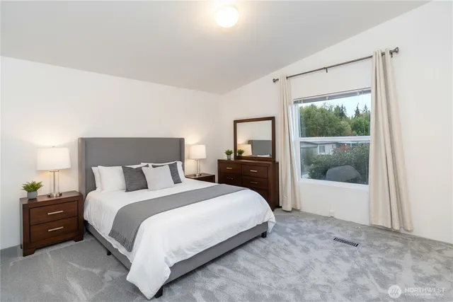 a large bed sitting in a bedroom next to a window