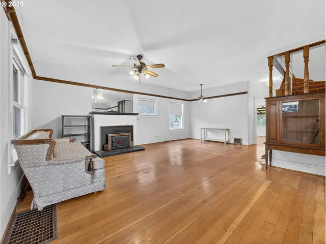 a view of empty room with fireplace and wooden floor