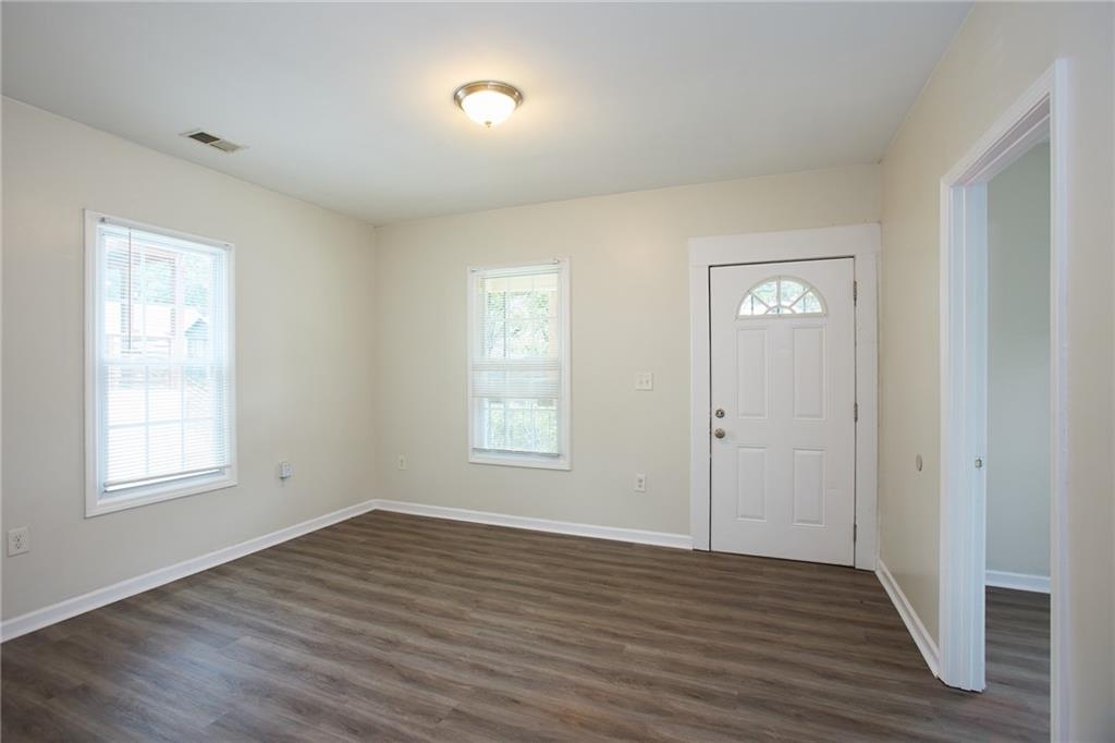 1049 Sims Street Southwest Atlanta, GA 30310 - Photo 7 of 9 an empty room with wooden floor and windows