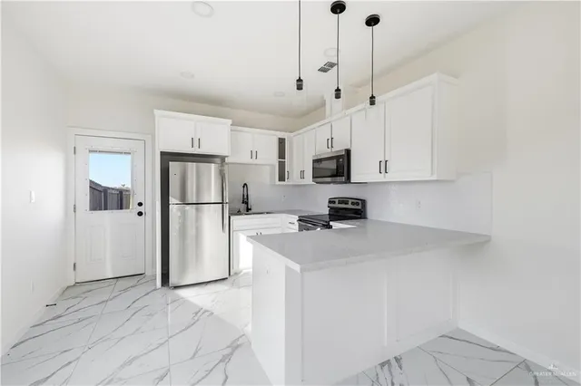 a kitchen with stainless steel appliances a refrigerator sink and white cabinets