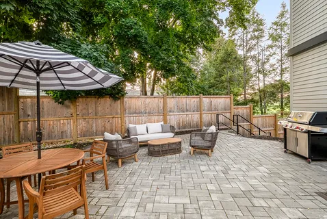 a backyard of a house with barbeque oven table and chairs