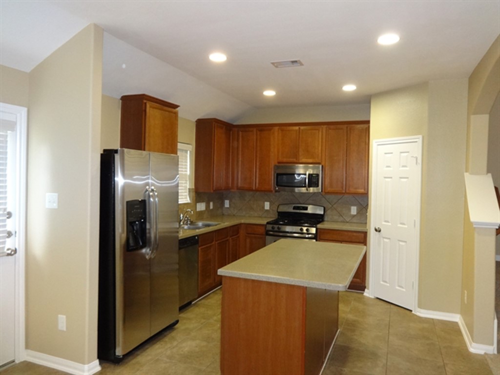 5318 Rio Drive Baytown, TX 77521 - Photo 2 of 11 a kitchen with a refrigerator a stove top oven a sink and dishwasher