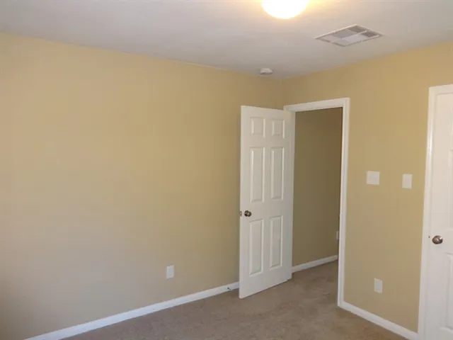 a view of a backyard with large trees and wooden fence