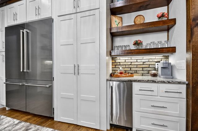 a en suite bathroom with a granite countertop double vanity sink and a mirror