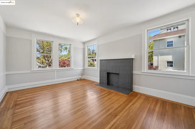 a view of empty room with wooden floor and fireplace
