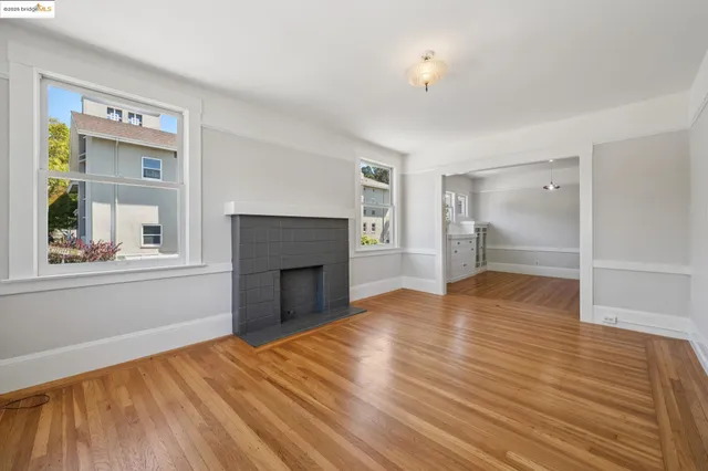 a view of empty room with wooden floor and fireplace