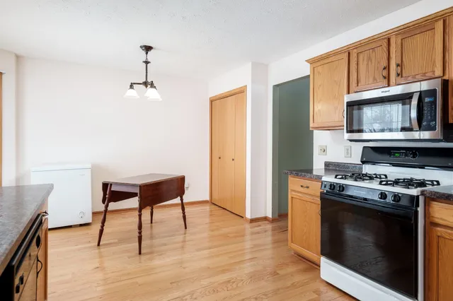 a kitchen with stainless steel appliances a stove a sink dishwasher and a refrigerator with wooden floor