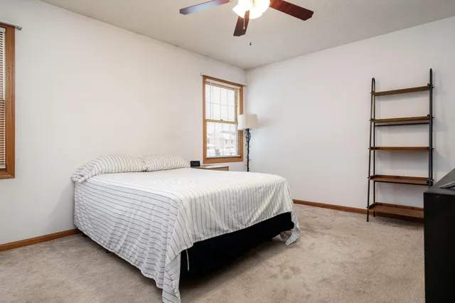 a bedroom with a bed and a ceiling fan