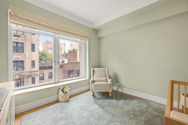 a bedroom with a bed a dresser and a large window
