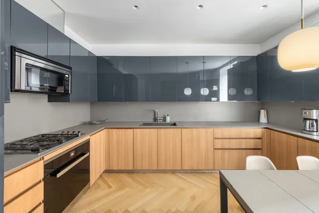 a kitchen with stainless steel appliances granite countertop a sink a stove and a wooden floors