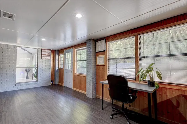 a view of a workspace with furniture and a window