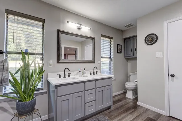 a bathroom with a toilet sink and mirror