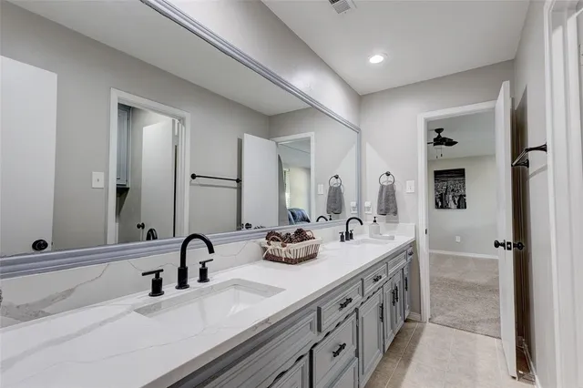 a bathroom with double sink and a mirror