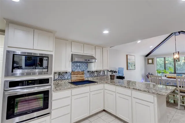 a kitchen with appliances a sink cabinets and a window