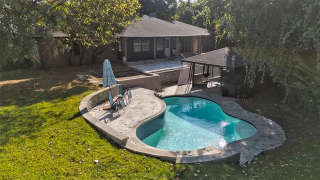 a swimming pool with outdoor seating yard and barbeque oven