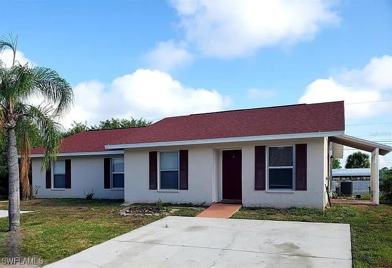 a front view of a house with a garden and yard