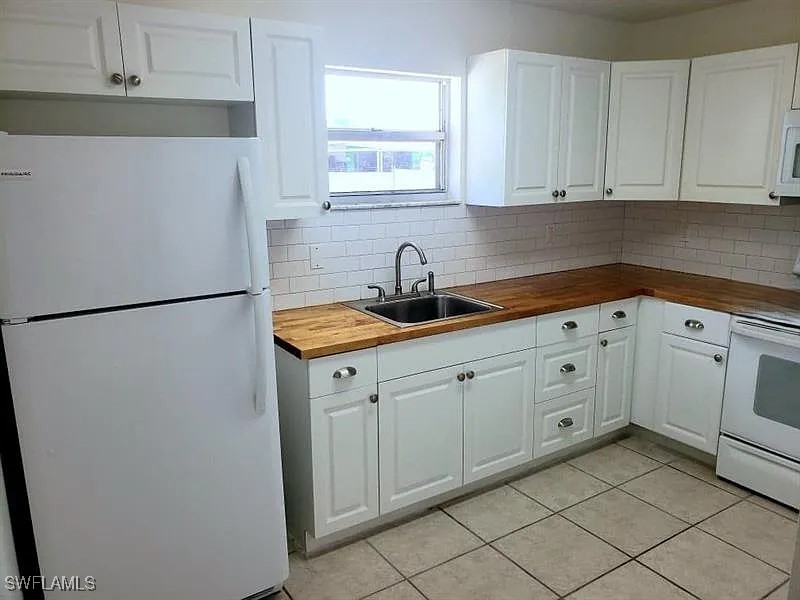 11216 Pendleton Avenue, Unit B Englewood, FL 34224 - Photo 5 of 10 a kitchen with a refrigerator and cabinets