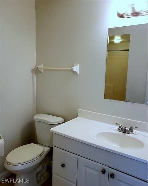 11216 Pendleton Avenue, Unit B Englewood, FL 34224 - Photo 6 of 10 a bathroom with a toilet a sink and mirror