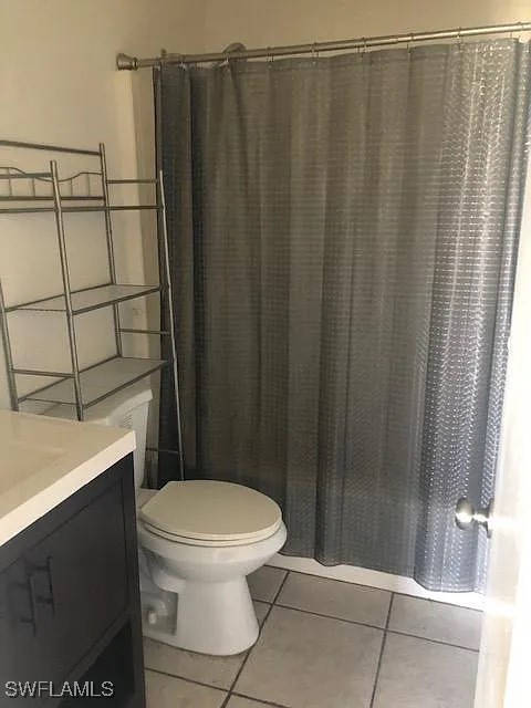 11216 Pendleton Avenue, Unit B Englewood, FL 34224 - Photo 9 of 10 a bathroom with a toilet and a shower curtain
