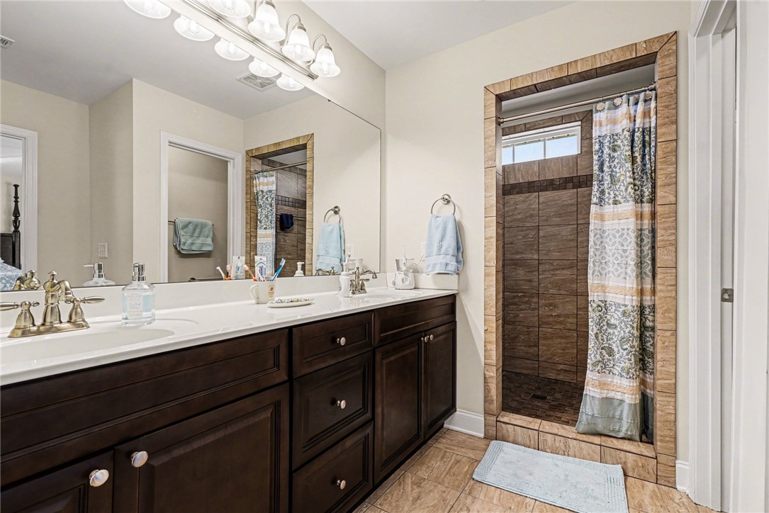 125 Apple Grove Drive Inman, SC 29349 - Photo 15 of 19 This bathroom features a double vanity and a tiled walk-in shower.
