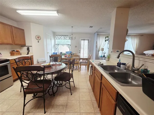 a kitchen with stainless steel appliances a sink table and chairs