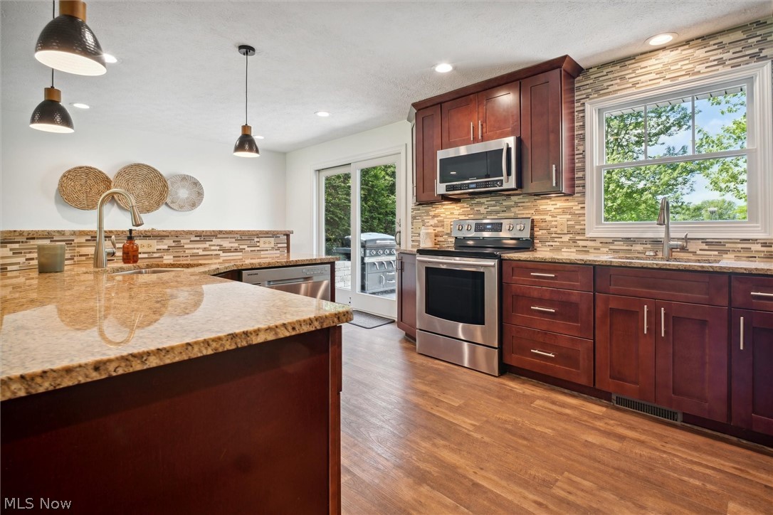 2035 Porter Road Atwater, OH 44201 - Photo 16 of 50 Kitchen with backsplash, pendant lighting, stainless steel appliances, and sink