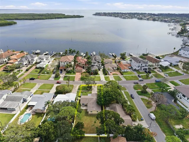 an aerial view of ocean and residential houses with outdoor space