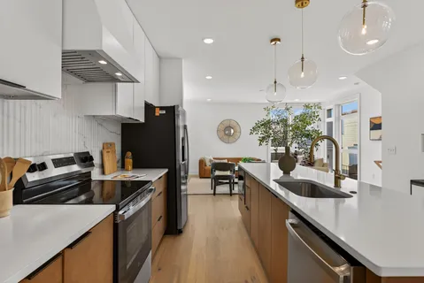 a kitchen with granite countertop a sink a counter top space stove and cabinets